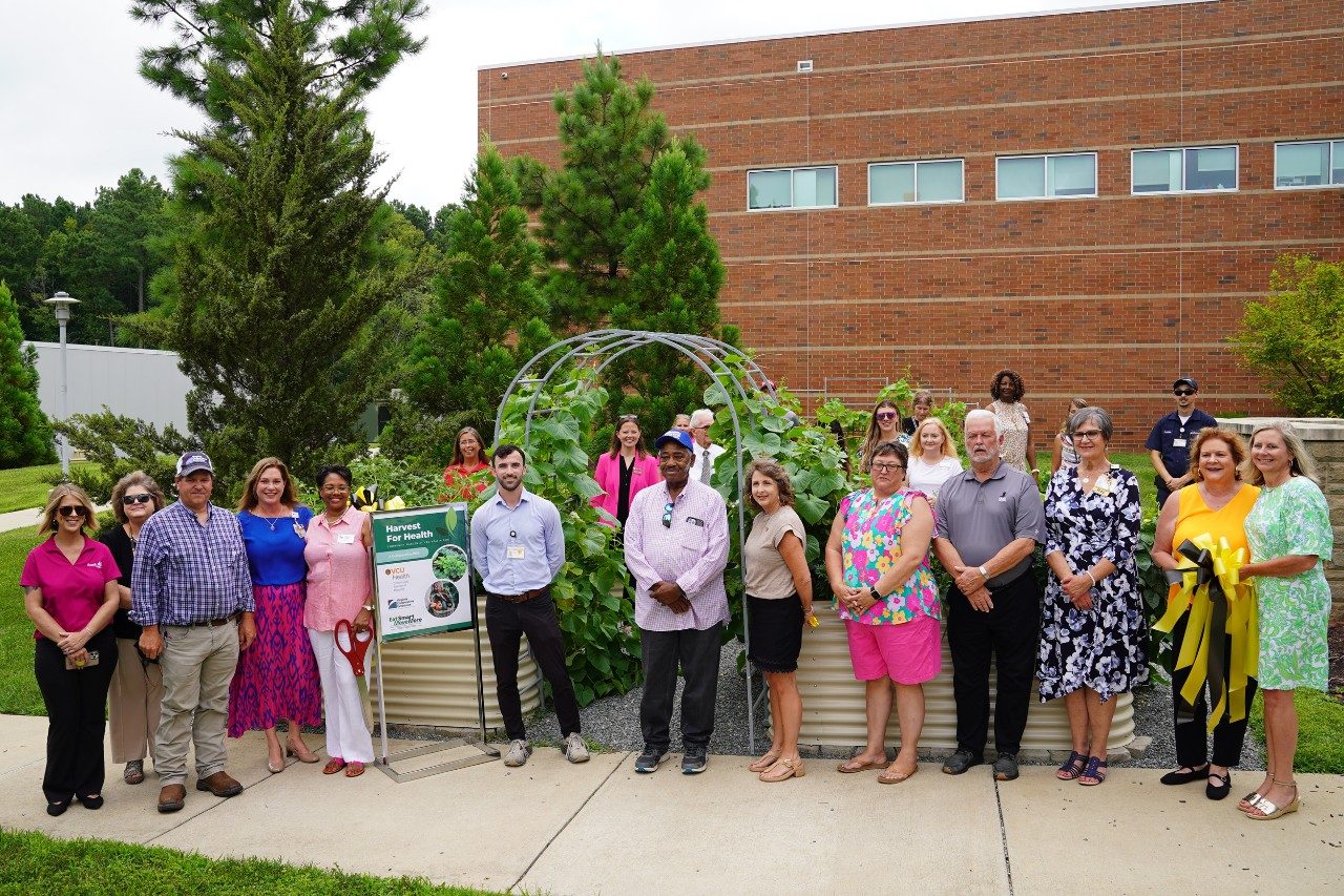 group of people standing in front of raised garden beds